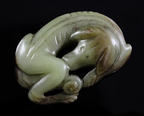 A Chinese greenish-yellow and brown jade carving of a recumbent hound, possibly Ming dynasty, 6.7cm